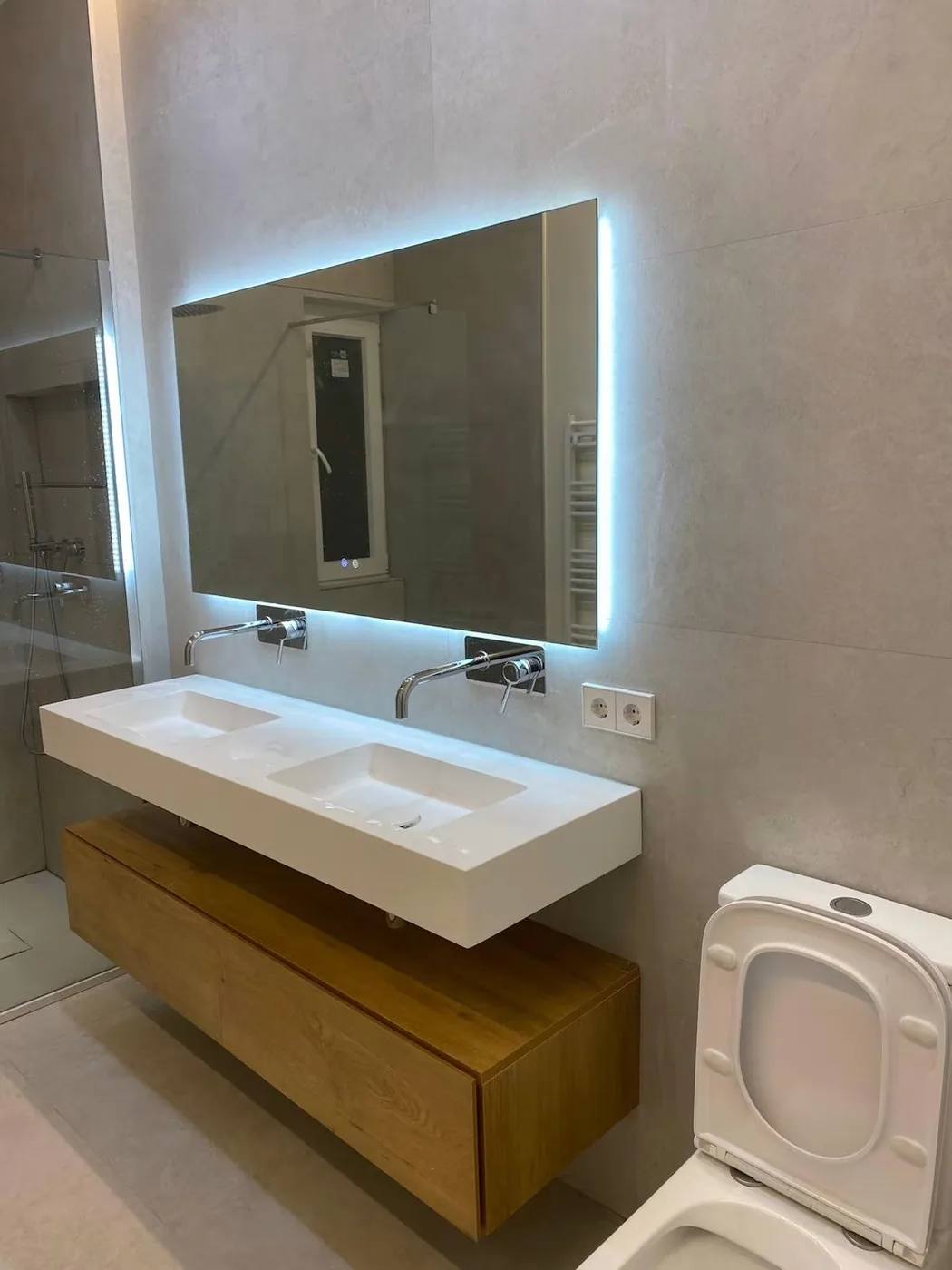 Baño reformado con doble lavabo y espejo retroiluminado